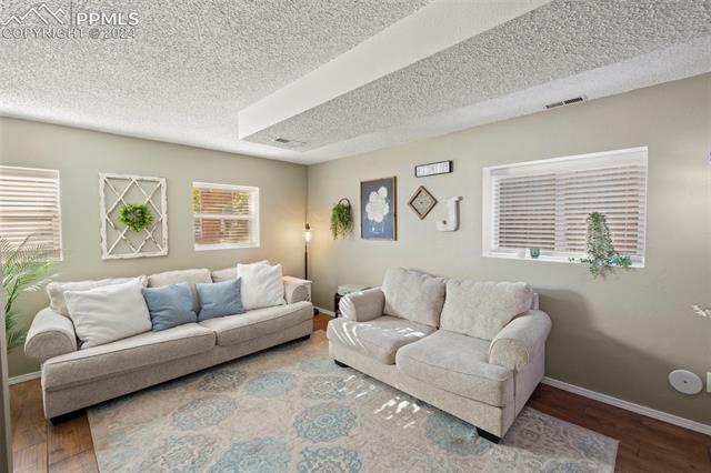 1830 Doherty Road Colorado Springs, CO 80916 - Photo 23 of 34 Living room with a textured ceiling and wood-type flooring