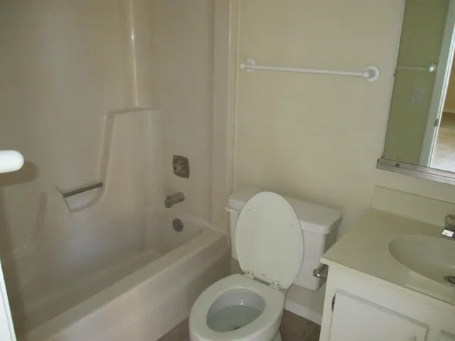 a white toilet sitting next to a bath tub