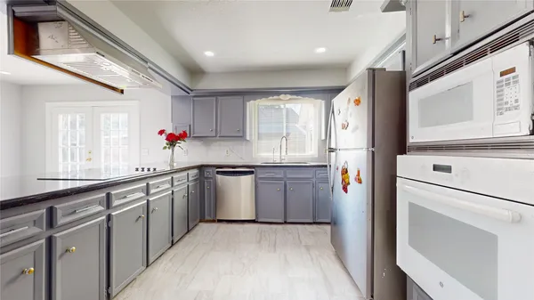 a kitchen with granite countertop cabinets stainless steel appliances a sink and a window