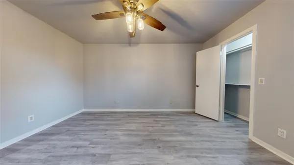 an empty room with closet and windows