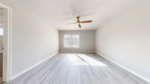 a view of a room with wooden floor ceiling fan