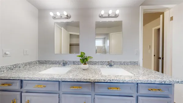 a bathroom with a granite countertop sink and white cabinets