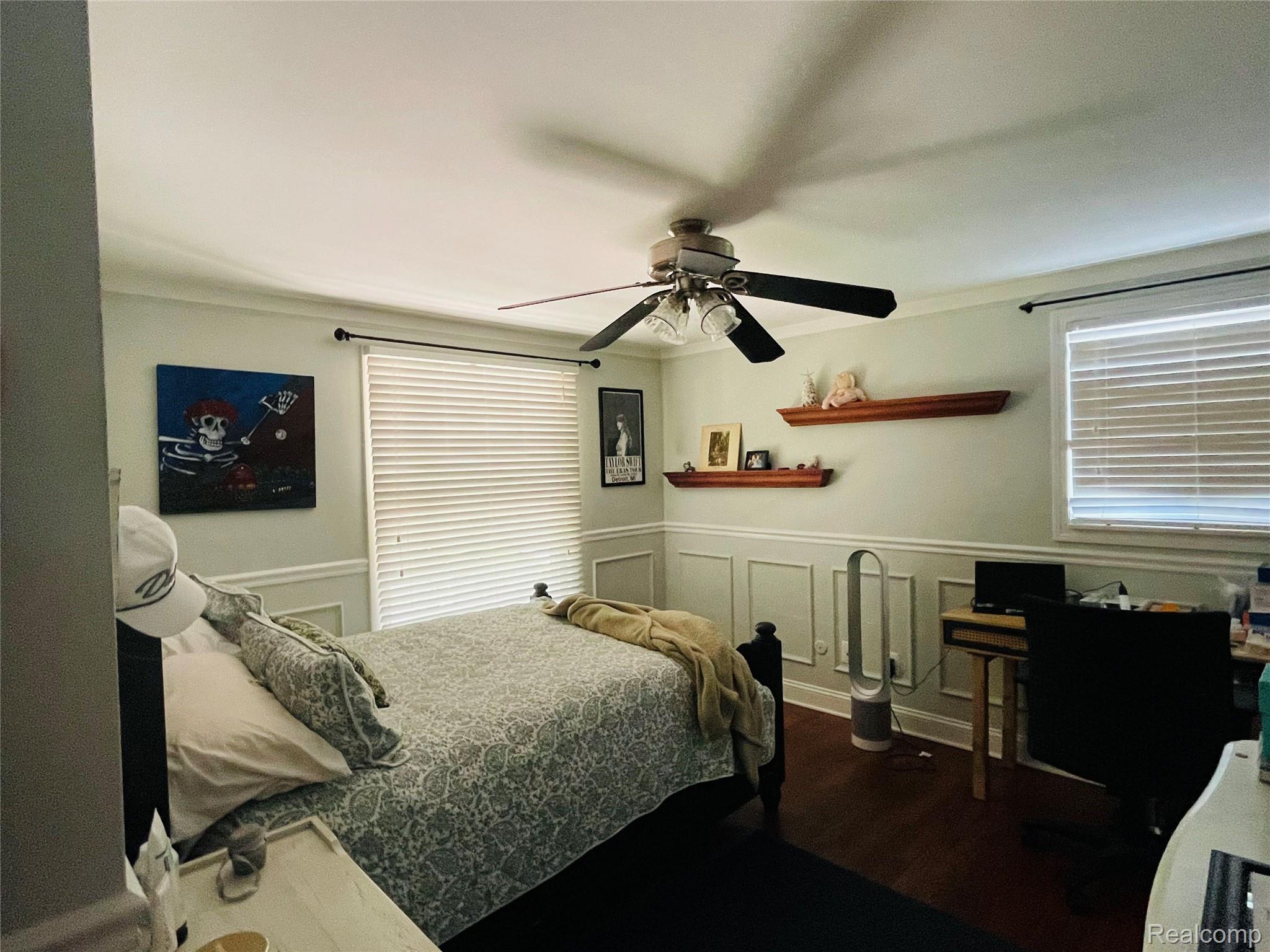 488 Welch Road Northville, MI 48167 - Photo 12 of 22 Bedroom featuring wood-finish flooring, wainscoting, crown molding, and a ceiling fan with integrated lighting