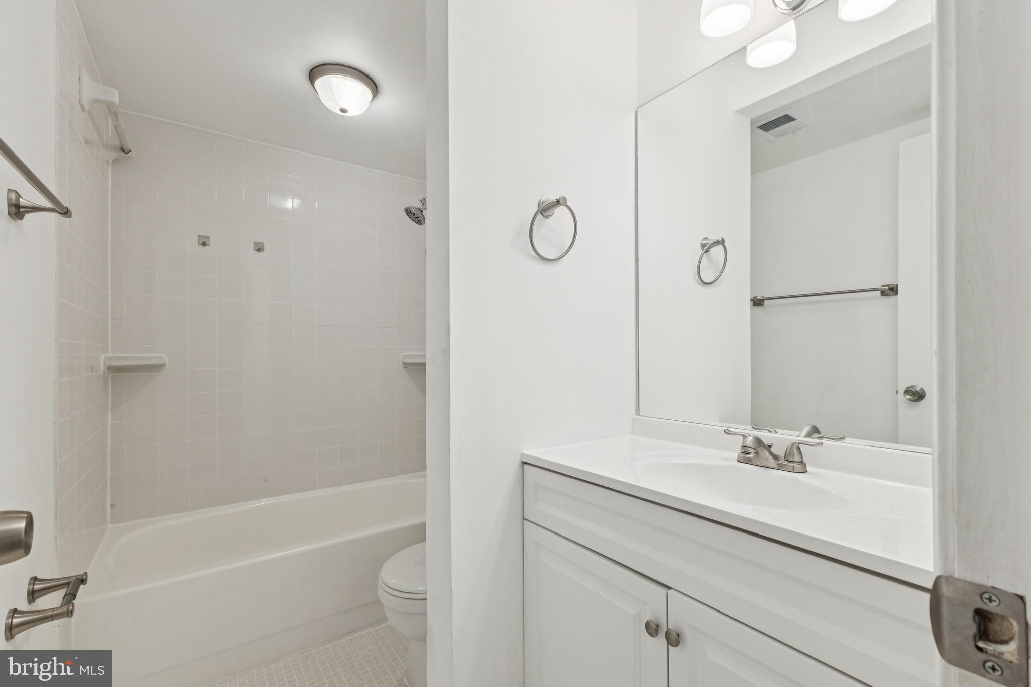 10271 Braddock Road Fairfax, VA 22032 - Photo 22 of 25 a bathroom with a bathtub shower sink vanity and a toilet