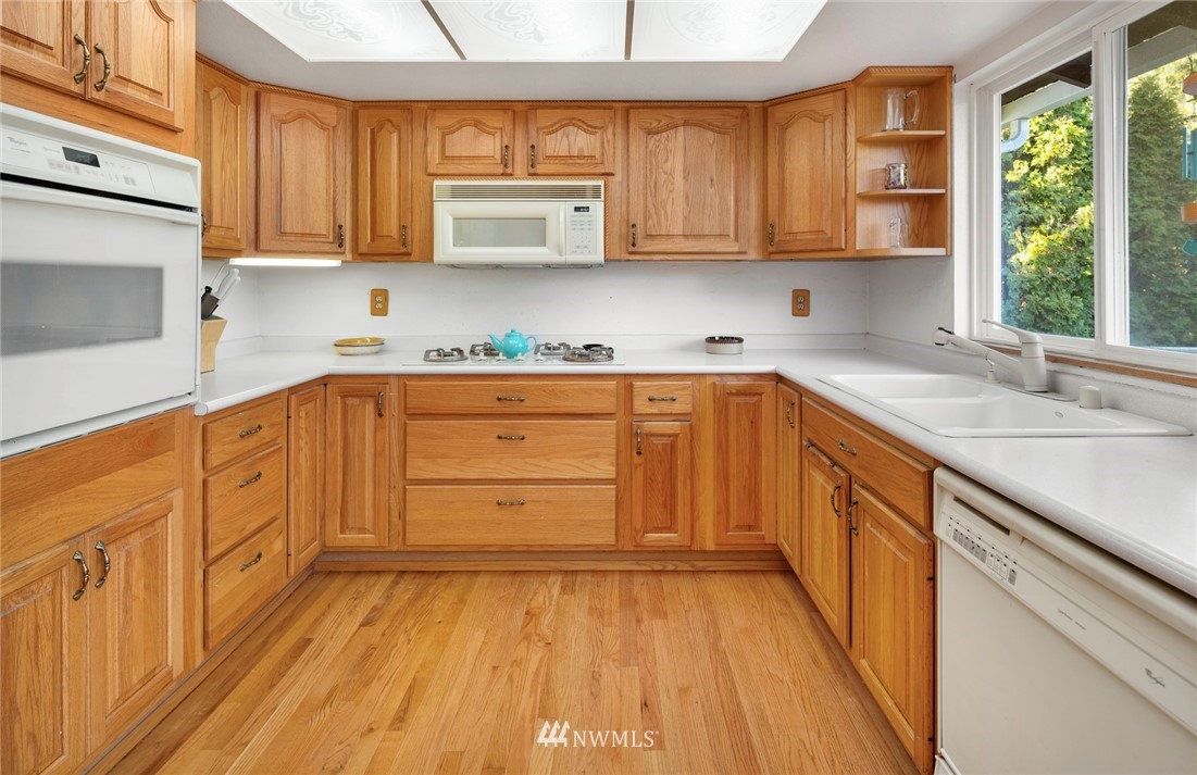21310 2nd Avenue Southeast Bothell, WA 98021 - Photo 8 of 22 a kitchen with stainless steel appliances granite countertop a sink a stove cabinets and wooden floor