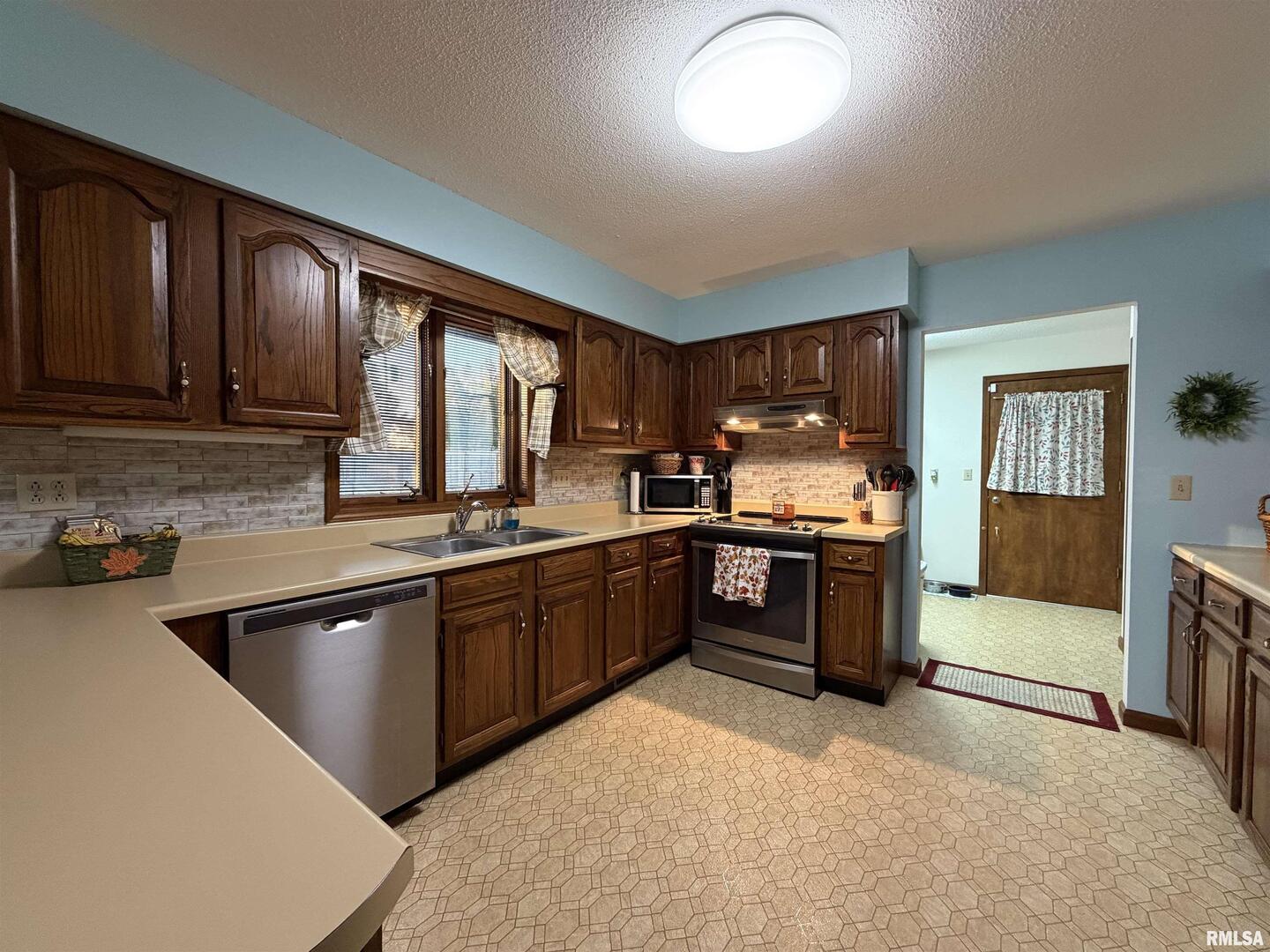 206 Daras Drive Carmi, IL 62821 - Photo 13 of 33 a kitchen with stainless steel appliances granite countertop wooden cabinets a stove top oven a sink and dishwasher
