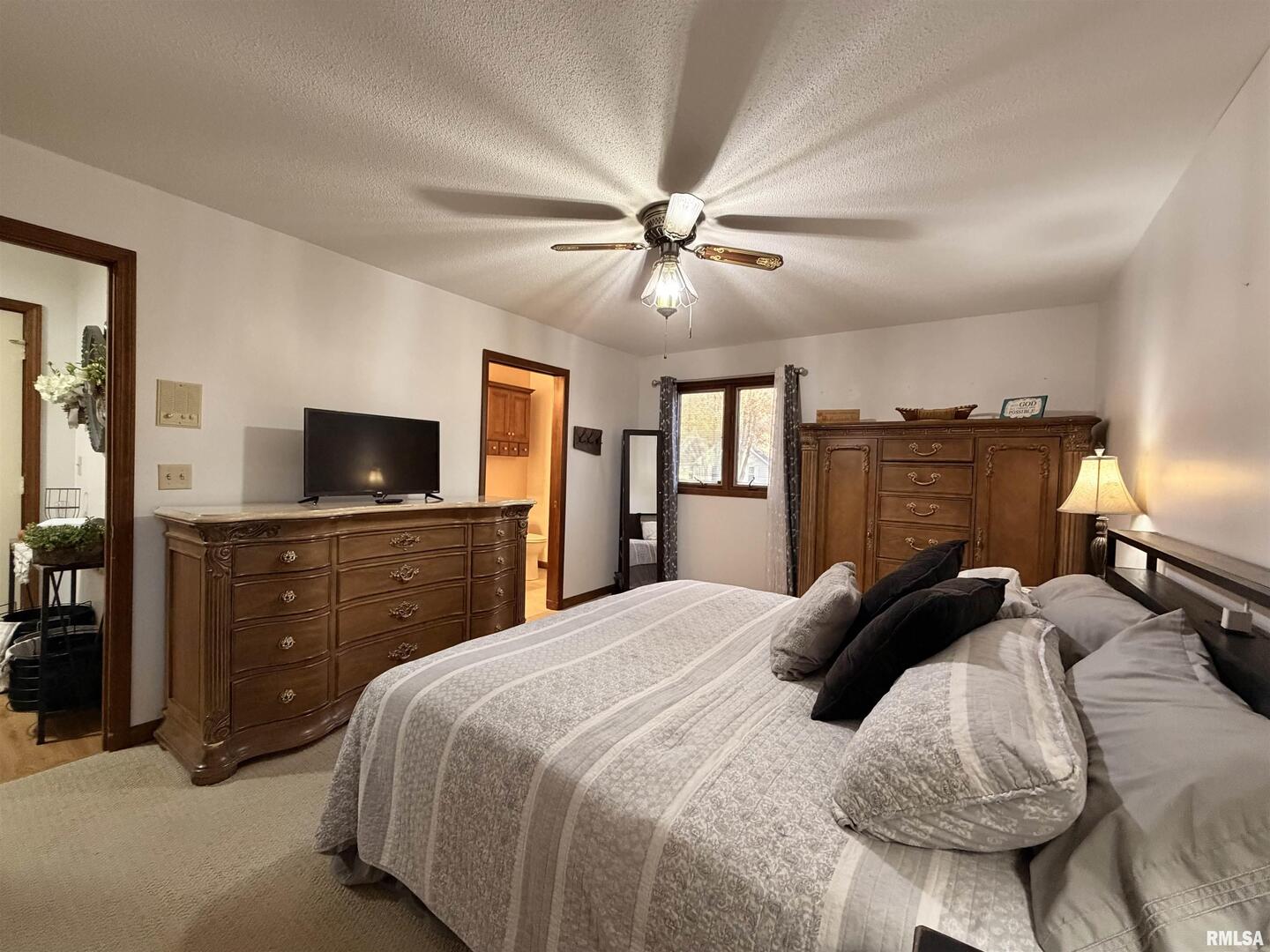 206 Daras Drive Carmi, IL 62821 - Photo 20 of 33 a bedroom with a large bed a flat tv screen and a chandelier