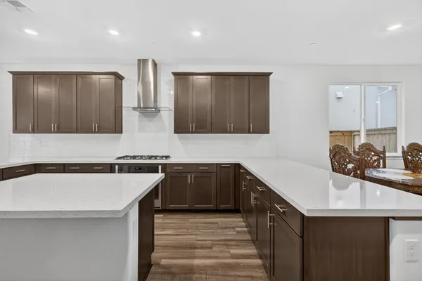 a kitchen with stainless steel appliances granite countertop a sink and dishwasher a stove with wooden floor