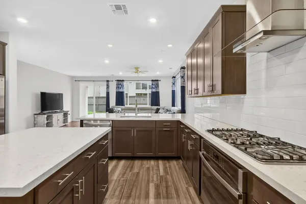 a kitchen with kitchen island a counter top space cabinets and stainless steel appliances