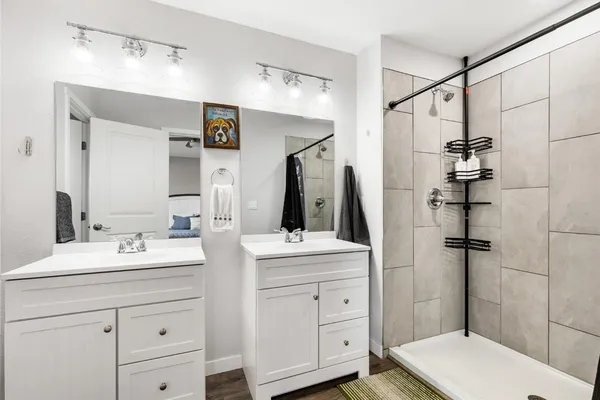 a bathroom with a double vanity sink toilet and shower