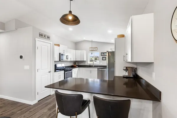 a kitchen with stainless steel appliances granite countertop a sink a stove and refrigerator