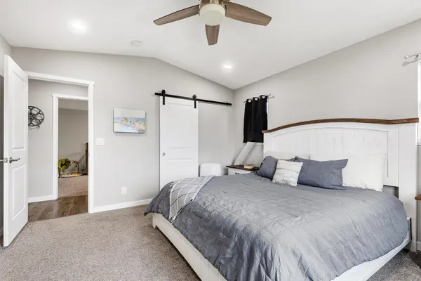 a bedroom with a large bed and a chandelier