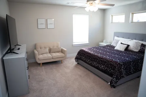 a bedroom with a bed couch and window