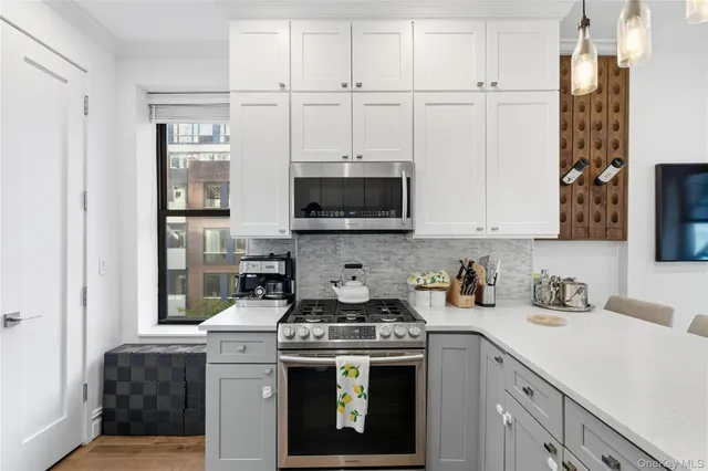 a kitchen with a sink a counter top space stainless steel appliances and cabinets