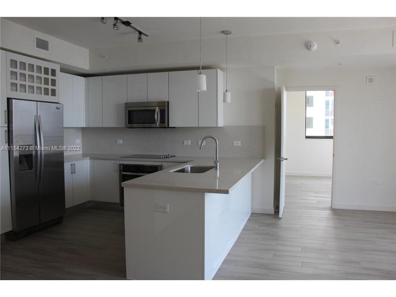 999 Southwest 1st Avenue, Unit 2502 Miami, FL 33130 - Photo 2 of 10 a kitchen with a refrigerator sink and cabinets