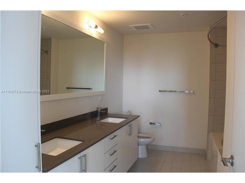 999 Southwest 1st Avenue, Unit 2502 Miami, FL 33130 - Photo 5 of 10 a bathroom with a sink and a mirror