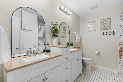 a bathroom with a toilet a sink a mirror and vanity