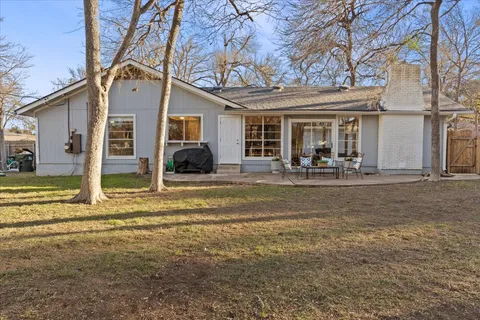 a view of a house with a big yard and large tree