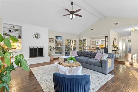 a living room with furniture a fireplace and a chandelier