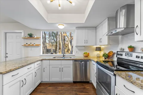 a kitchen with stainless steel appliances granite countertop a sink stove and cabinets