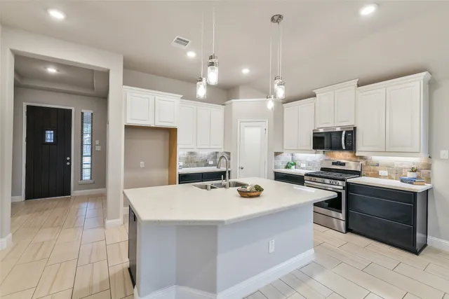 a kitchen with kitchen island a sink stove and refrigerator
