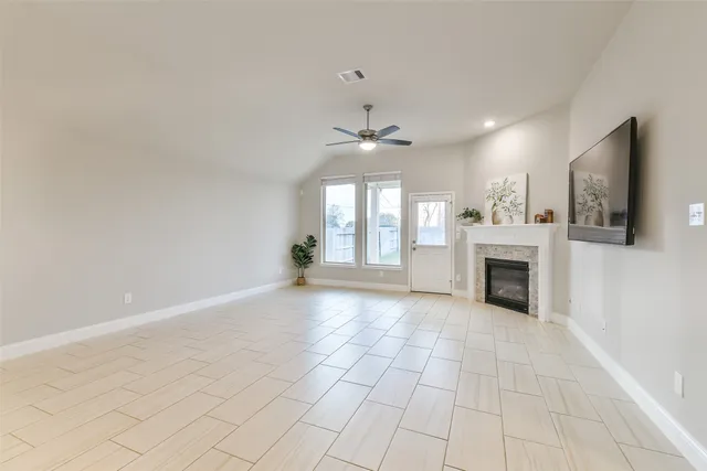 a view of an empty room with a fireplace and a window
