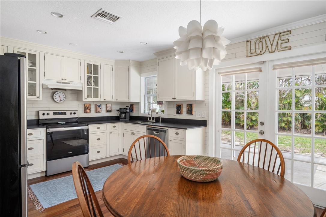 3496 1st Street Southwest Vero Beach, FL 32968 - Photo 10 of 30 a kitchen with a table chairs a stove and cabinets