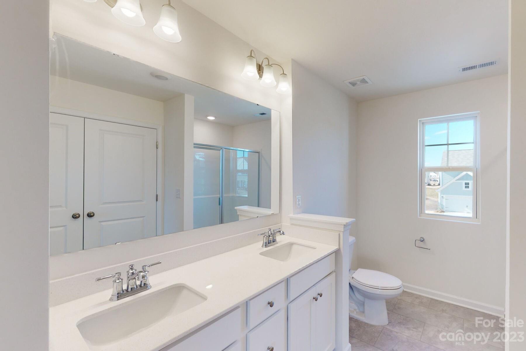 2650 Trinity Street Monroe, NC 28110 - Photo 25 of 36 a bathroom with a granite countertop sink a toilet and a mirror