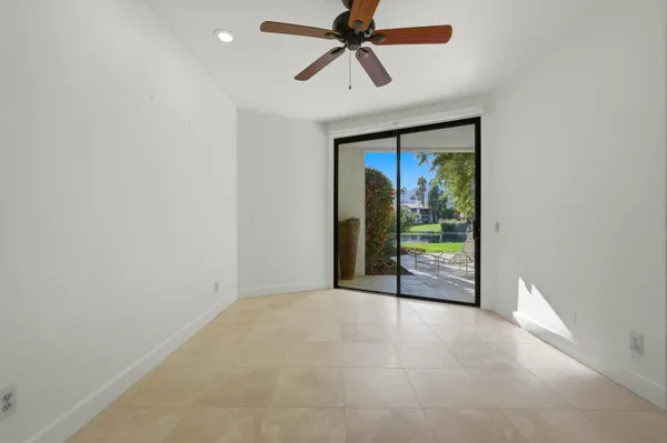 an empty room with closet and fan