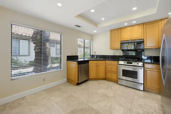 a kitchen with stainless steel appliances granite countertop a stove and a refrigerator