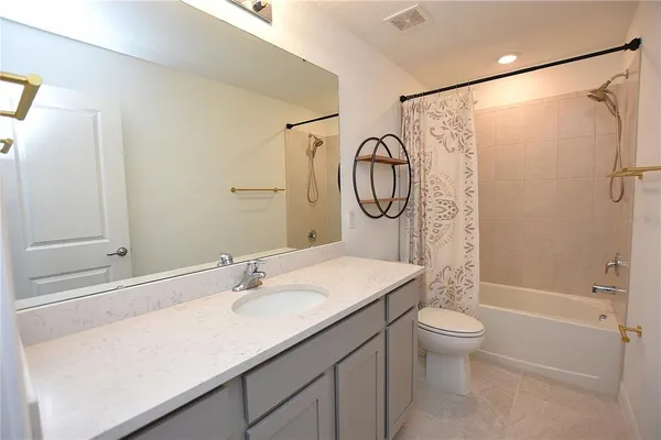 a spacious bedroom with a bed and a potted plant