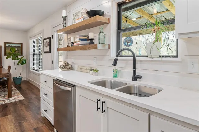 a kitchen with a sink and a wooden floor