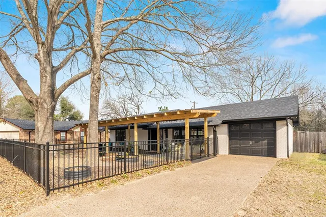 a front view of a house with a large tree