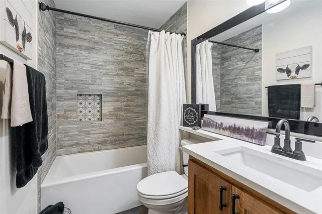 a bathroom with a sink a toilet a mirror and shower