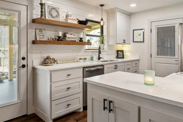 a kitchen with a sink a stove and cabinets