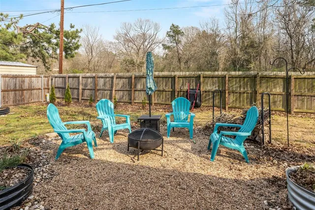 a view of a chairs and table in the back yard