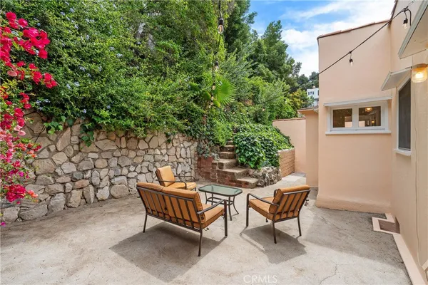 a backyard of a house with barbeque oven table and chairs