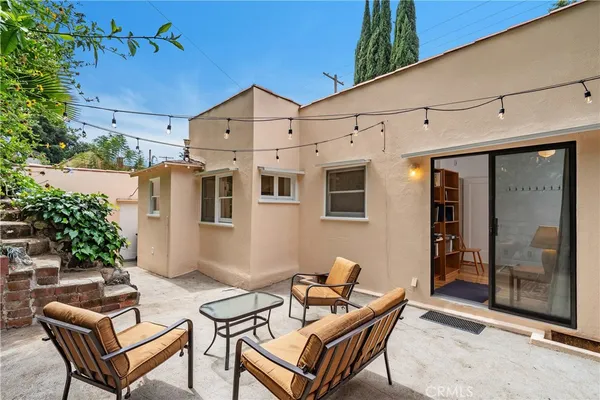 a backyard of a house with table and chairs