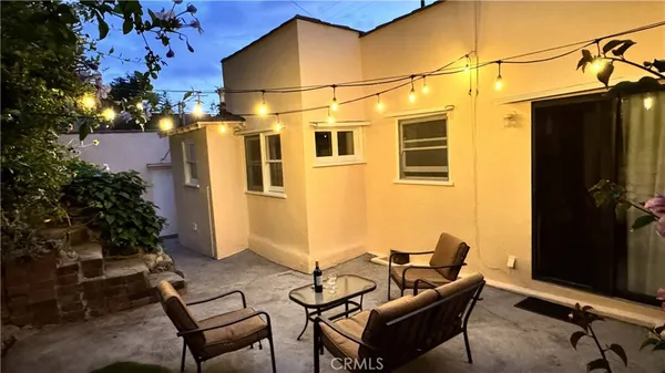 a backyard of a house with table and chairs