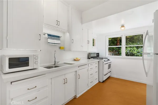 a kitchen with cabinets appliances and a window