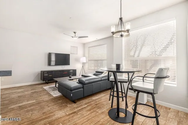a living room with furniture a flat screen tv and a window