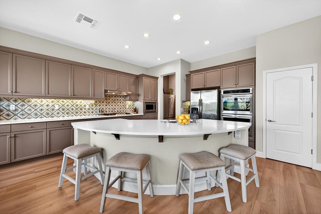 2208 Raintree Court Rocklin, CA 95765 - Photo 10 of 46 a kitchen with a table chairs refrigerator cabinets and wooden floor