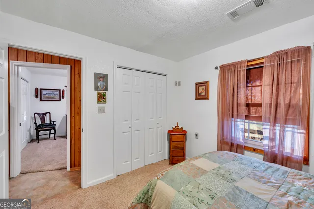 a view of a house with a small yard and a large tree