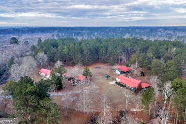 a view of swimming pool with outdoor seating and trees in the background