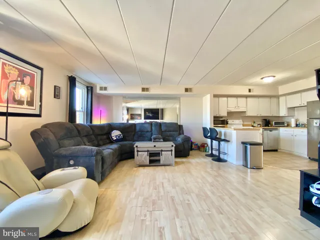 a living room with furniture kitchen view and a window