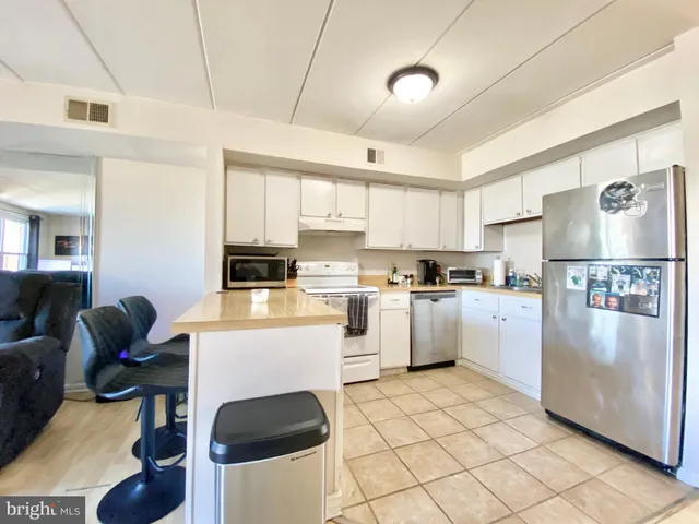 a kitchen with stainless steel appliances granite countertop a stove a sink dishwasher and a refrigerator