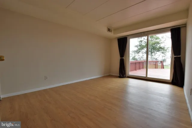 a view of empty room with wooden floor and fireplace