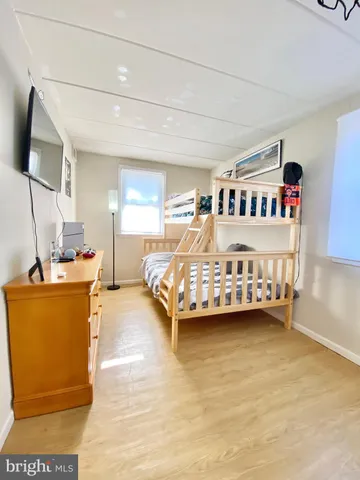 a bedroom with a bed furniture and a flat tv screen