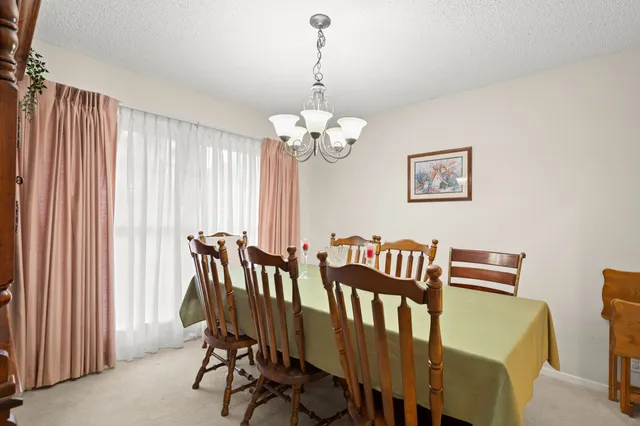 a view of a dining room with furniture and chandelier