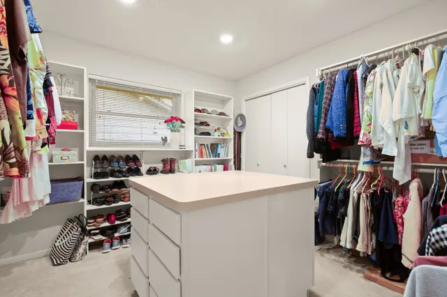 a view of walk in closet with clothes and shoes